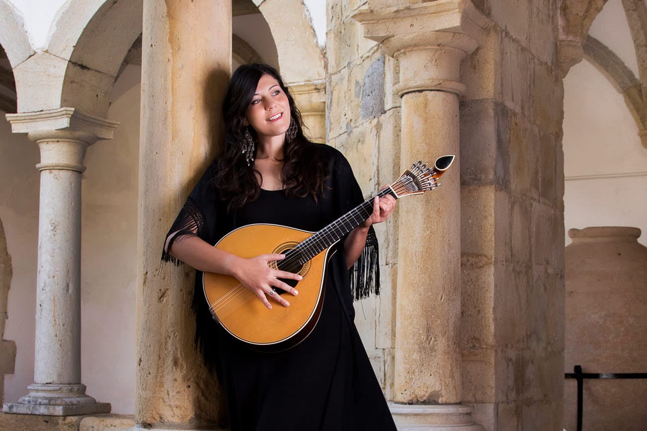 Musician with a Portuguese guitar in a cloister